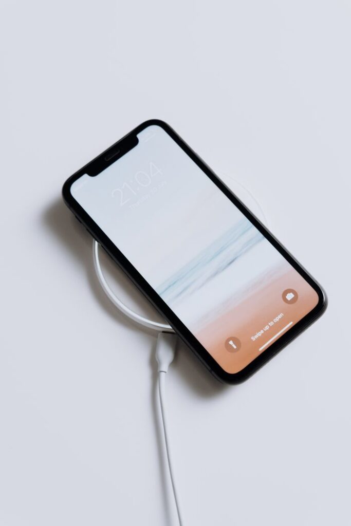 A sleek smartphone charging wirelessly, showcasing minimalist design and modern technology.