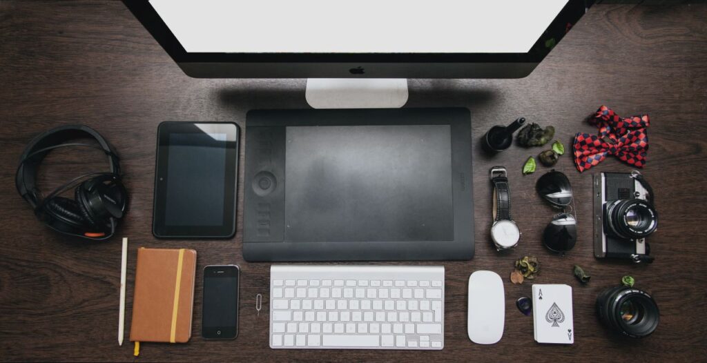 Organized workspace with tech devices and accessories on a wooden desk.